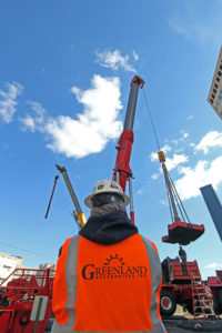 Greenland Enterprises employee back watching crane lifting equipment