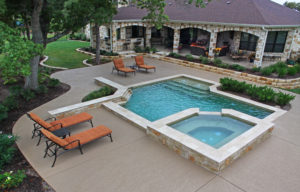 backyard pool with hot tub in wooded backyard