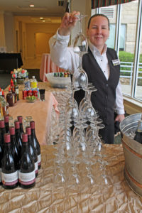 hotel employee stacking wine glasses