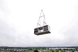 crane lifting HVAC equipment onto roof