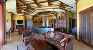 great room with woodwork ceiling details and yellow and dark red decor