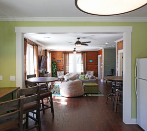 long shot from kitchen looking towards living room with rustic and green decor