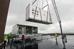 crane lifting HVAC equipment on roof