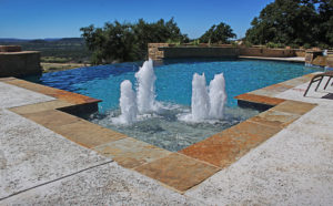 fountain feature in backyard pool with infinity edge