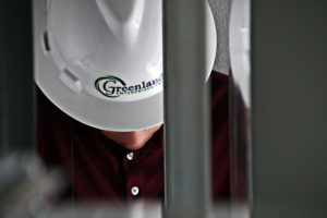 Greenland Enterprises hard hat employee looking down