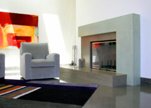 modern stained concrete fireplace with abstract art and easy chair