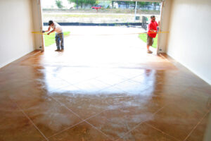 two men measuring inside garage with stained concrete